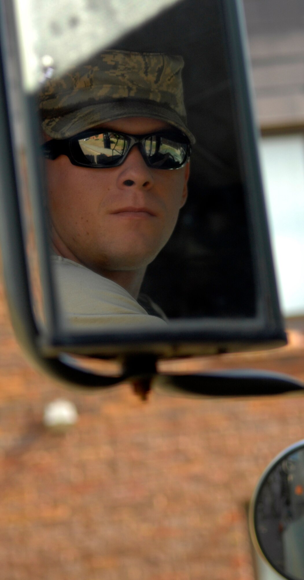 RAF MILDENHALL, England -- Senior Airman Jordan Lamm, 100th Civil Engineer Squadron, watches for signals from Richard Austin as they clean rain drains around base.  The team uses a high-powered vacuum hose to suck leaves, sticks and other debris from the drainage system, ensuring parking lots and roads stay clear during rainy periods. (U.S. Air Force photo/Staff Sgt. Austin M. May)