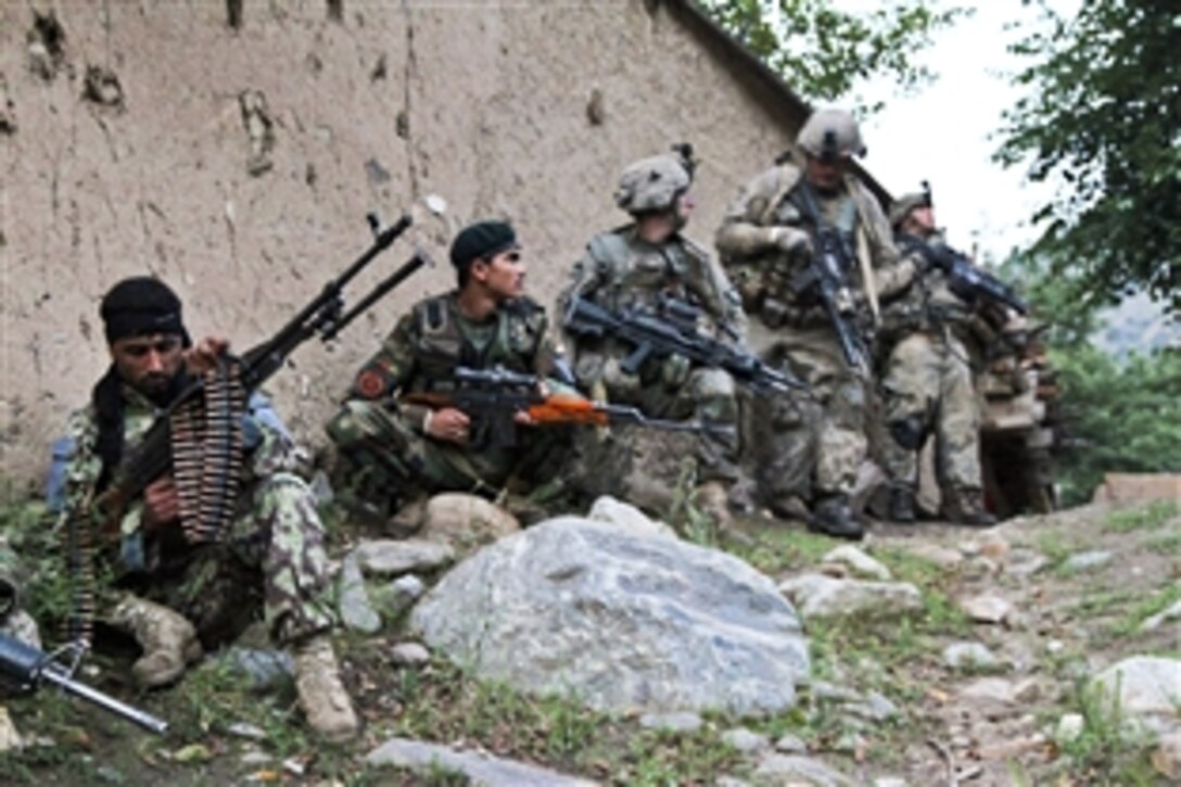 U.S. and Afghan soldiers sit along the wall in the town of Badmuk, Barg-e Matal, Afghanistan, Aug. 2, 2010. The U.S. Army soldiers are assigned to Company B, 1st Battalion, 327th Infantry Regiment.