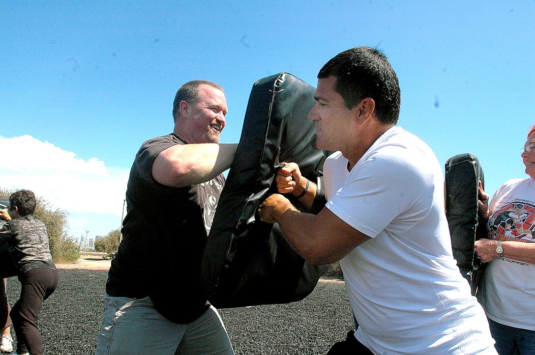 Chris Davis, a teacher at Mountain View High School, left, continuously elbow strikes partner, Mario Gonzalez, a coach at Lemoore High School, right, during the Marine Corps Martial Arts portion of the Educators Workshop here, Aug. 3.