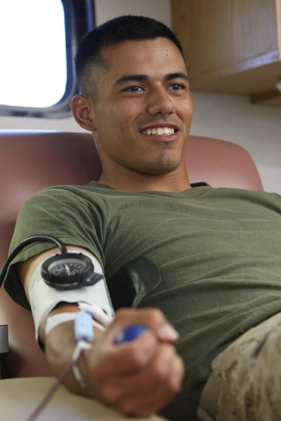 Pfc. Omero Vera, a recent graduate of D Company, Infantry Traing Battalion, School of Infantry- East, squeezes a stress ball every four seconds while donating blood inside the Armed Service Blood Program's mobile unit, parked just inside Camp Geiger, Aug. 5.