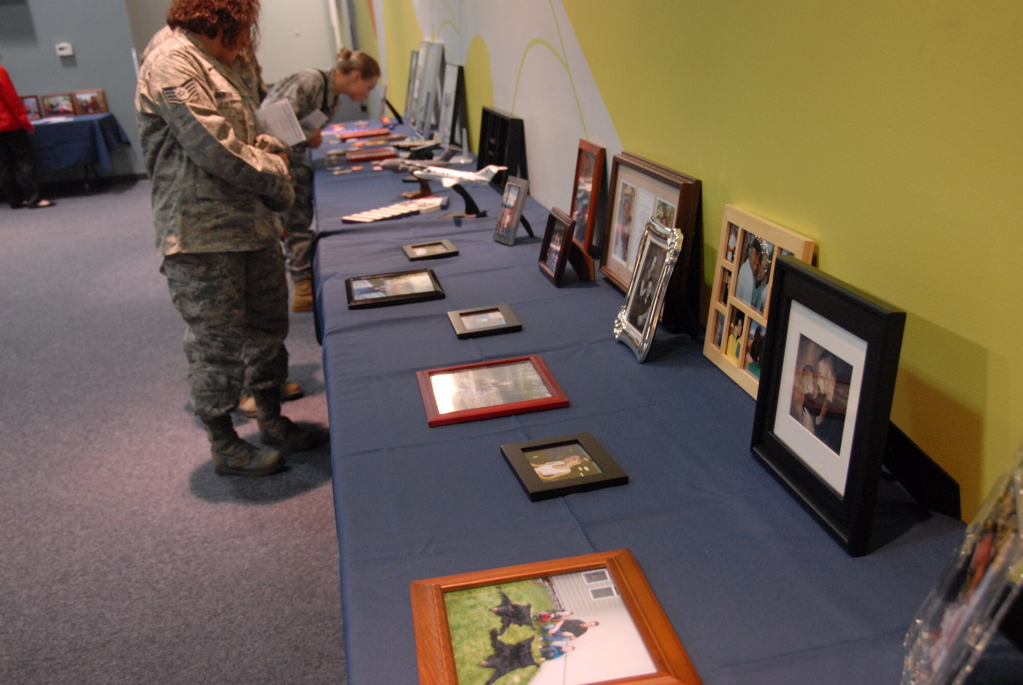 Photos of Capt. Jeffrey Hill and his family adorned the tables in the reception center at Change Point Church in Anchorage, Alaska during his memorial service August 4. Captain Hill was one of four crewmembers that perished in the C-17 crash on Elmendorf AFB July 28. Lt. Col. Hubie Hegtvedt, 302nd Fighter Squadron commander a Reserve squadron under the 477th Fighter Group, along with three other pilots from the 525th Fighter Squadron flew an F-22 missing man formation before the memorial service began. (Air Force Photo/Capt. Ashley Conner)