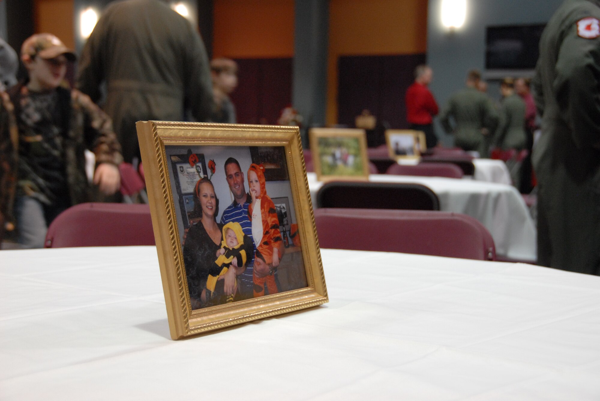 Photos of Capt. Jeffrey Hill and his family adorned the tables in the reception center at Change Point Church in Anchorage, Alaska during his memorial service August 4. Captain Hill was one of four crewmembers that perished in the C-17 crash on Elmendorf AFB July 28. Lt. Col. Hubie Hegtvedt, 302nd Fighter Squadron commander a Reserve squadron under the 477th Fighter Group, along with three other pilots from the 525th Fighter Squadron flew an F-22 missing man formation before the memorial service began. (Air Force Photo/Capt. Ashley Conner)