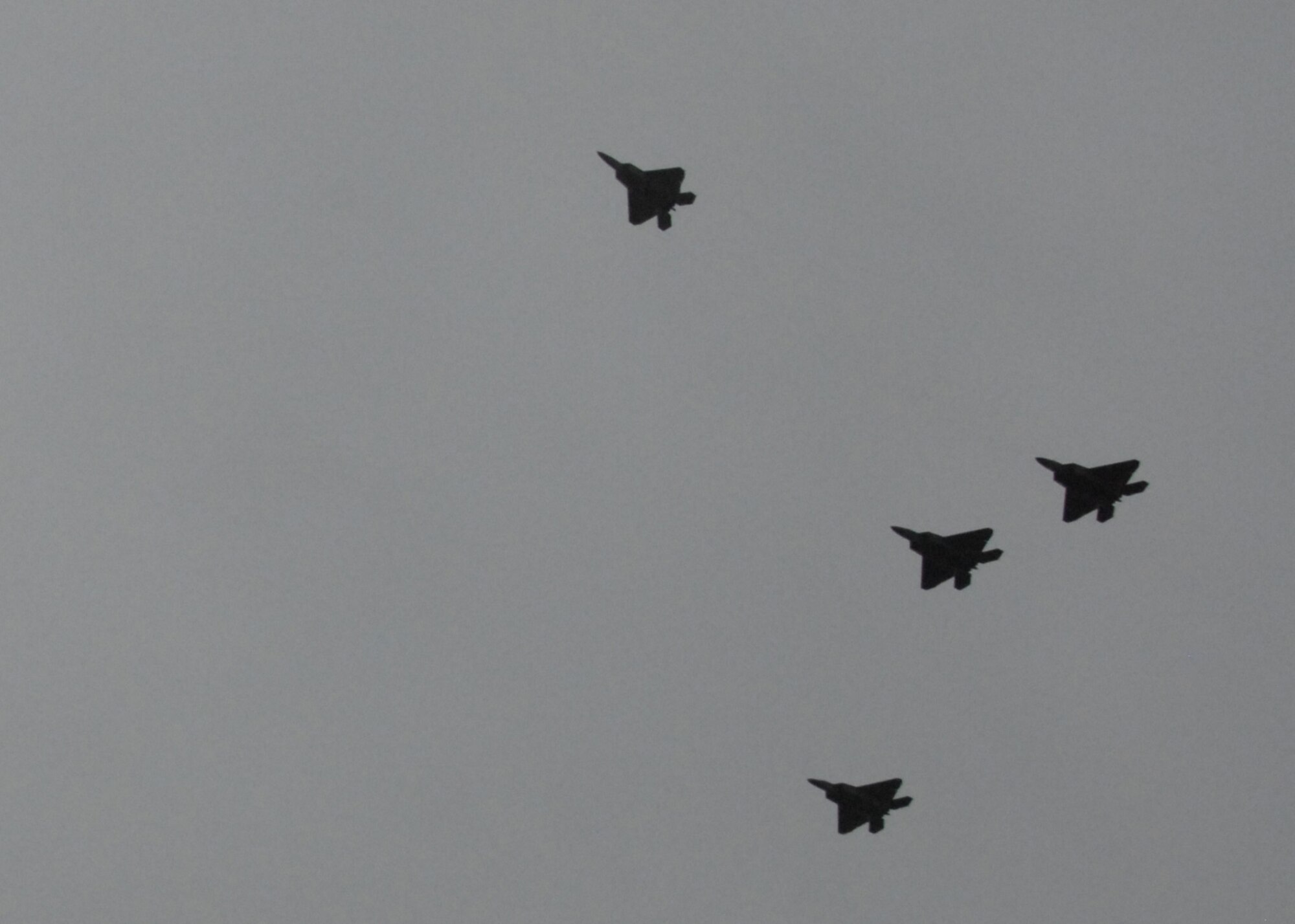 Lt. Col. Hubie Hegtvedt, 302nd Fighter Squadron commander a Reserve squadron under the 477th Fighter Group, along with Lt. Col. Chris Niemi, Maj. Leopold Lemelson, and Capt. Vaimana Conner, all from the 525th Fighter Squadron, fly an F-22 missing man formation over the memorial service for Capt. Jeffrey Hill in Anchorage August 4. Captain Hill was killed in a C-17 crash on Elmendorf  AFB July 28. Two of the pilots in the formation flew American flags that will be presented to the wife and parents of Captain Hill. (Air Force Photo/Capt. Ashley Conner)