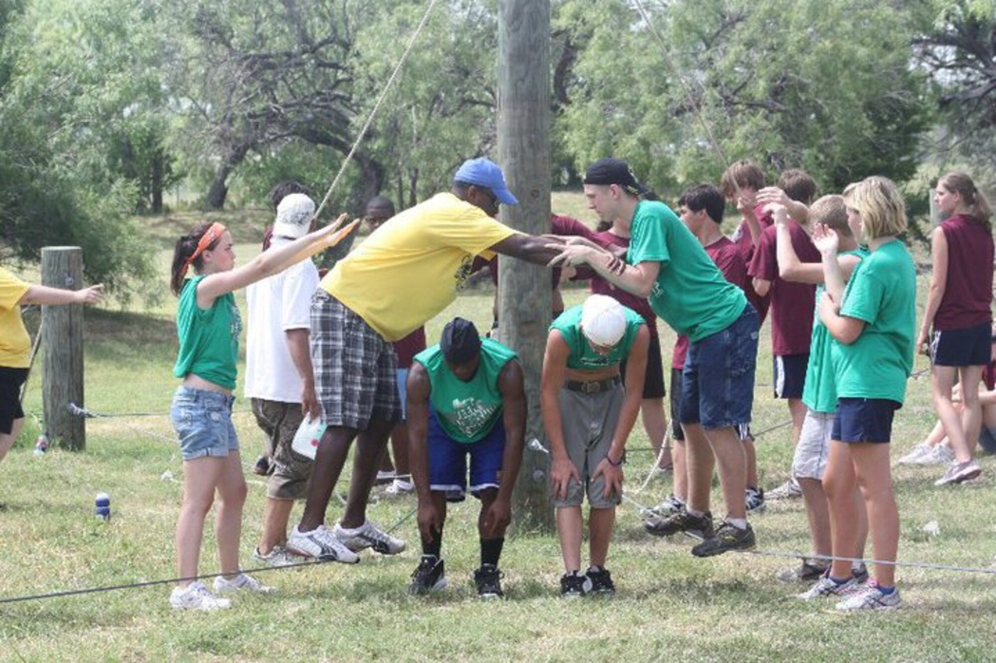 LACKLAND AIR FORCE BASE, Texas -- Teens work together to traverse a low-ropes course obstacle at Lackland Air Force Base, Texas, July 13. The teens also had the chance to complete a high-ropes course and zip line. Courtesy Photo 