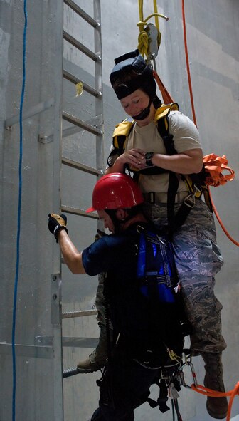A member of the Kent County Special Operations team carries "victim" Tech. Sgt. Tammy Hintz of the 436th Aeromedical Squadron to safety inside the new one million gallon water tank on Dover Air Force Base, Del., July 24, 2010. The 436th Civil Engineer Squadron Fire Department hosted a "confined space rescue" training and exercise at the CE compound. (U.S. Air Force photo by Roland Balik/Released)