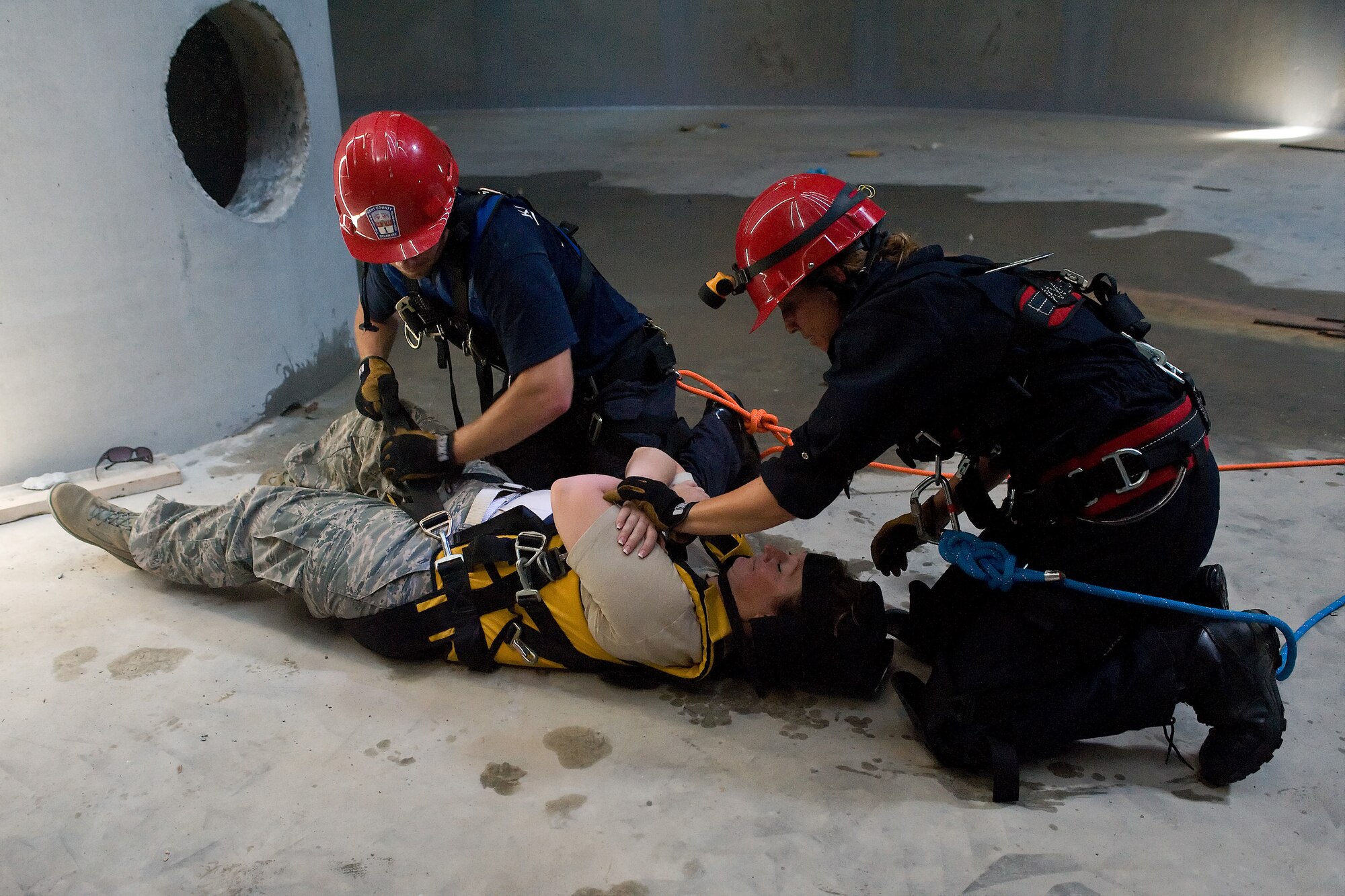 Two members of the Kent County Special Operations team strap up and secure Tech. Sgt. Tammy Hintz of the 436th Aerospace Medical Squadron during an exercise at the new one million gallon water tank on Dover Air Force Base, Del., July 24, 2010. The 436th Civil Engineer Squadron Fire Department hosted a "confined space rescue" training and exercise at the CE compound. (U.S. Air Force photo by Roland Balik/Released)