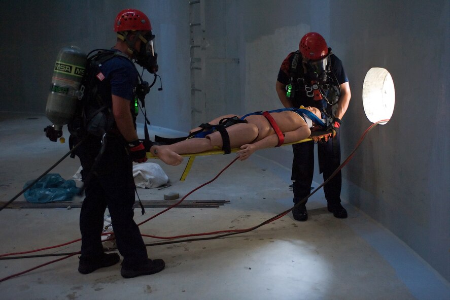Two members of the Kent County Special Operations team carry a victim to safety inside the new one million gallon water tank on Dover Air Force Base, Del., July 24, 2010. The 436th Civil Engineer Squadron Fire Department hosted a "confined space rescue" training and exercise at the CE compound. (U.S. Air Force photo by Roland Balik/Released)