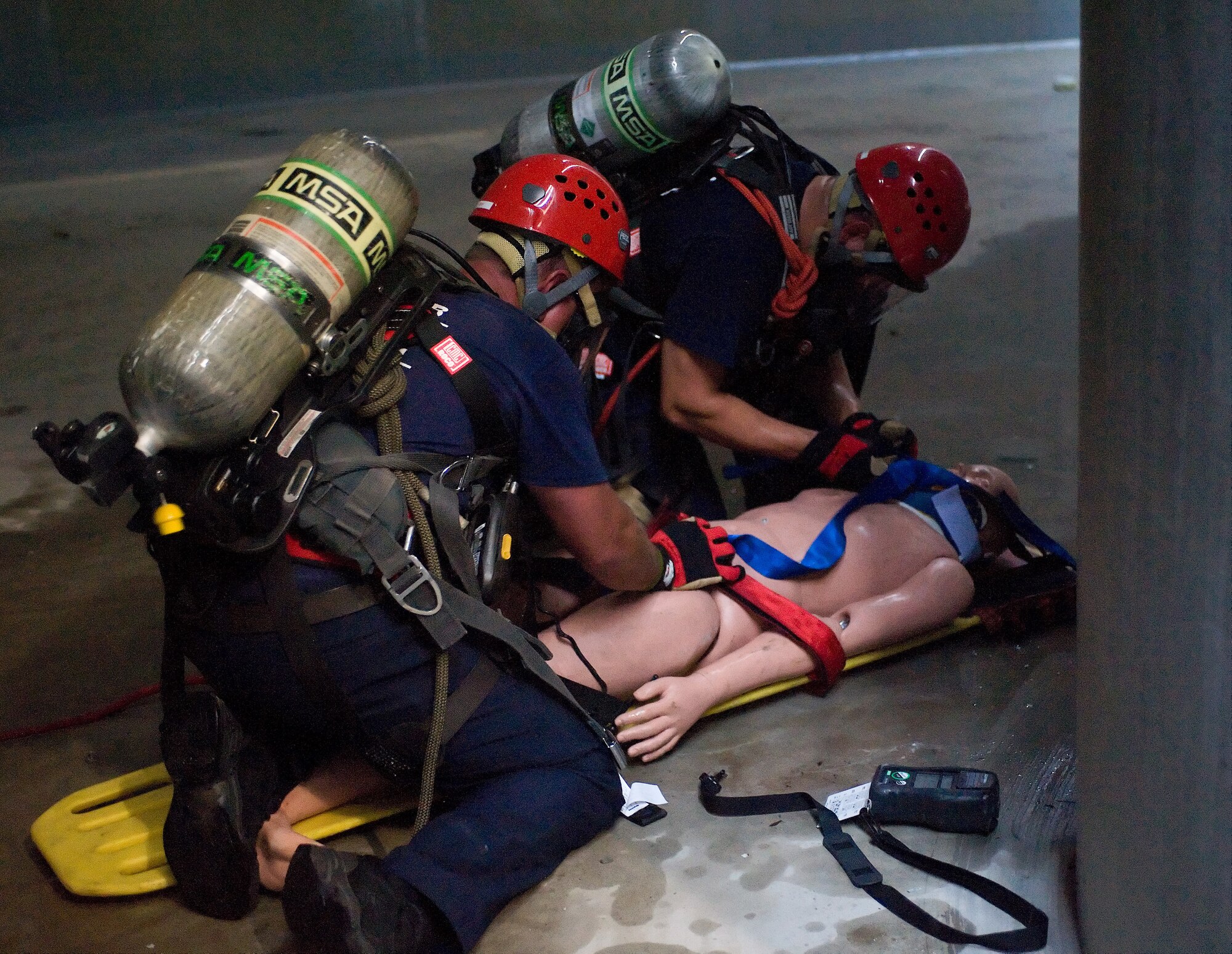 Two members of the Kent County Special Operations team secure a mannequin to a litter inside the new one million gallon water tank on Dover Air Force Base, Del., July 24, 2010. The 436th Civil Engineer Squadron Fire Department hosted a "confined space rescue" training and exercise event at the CE compound. (U.S. Air Force photo by Roland Balik/Released)