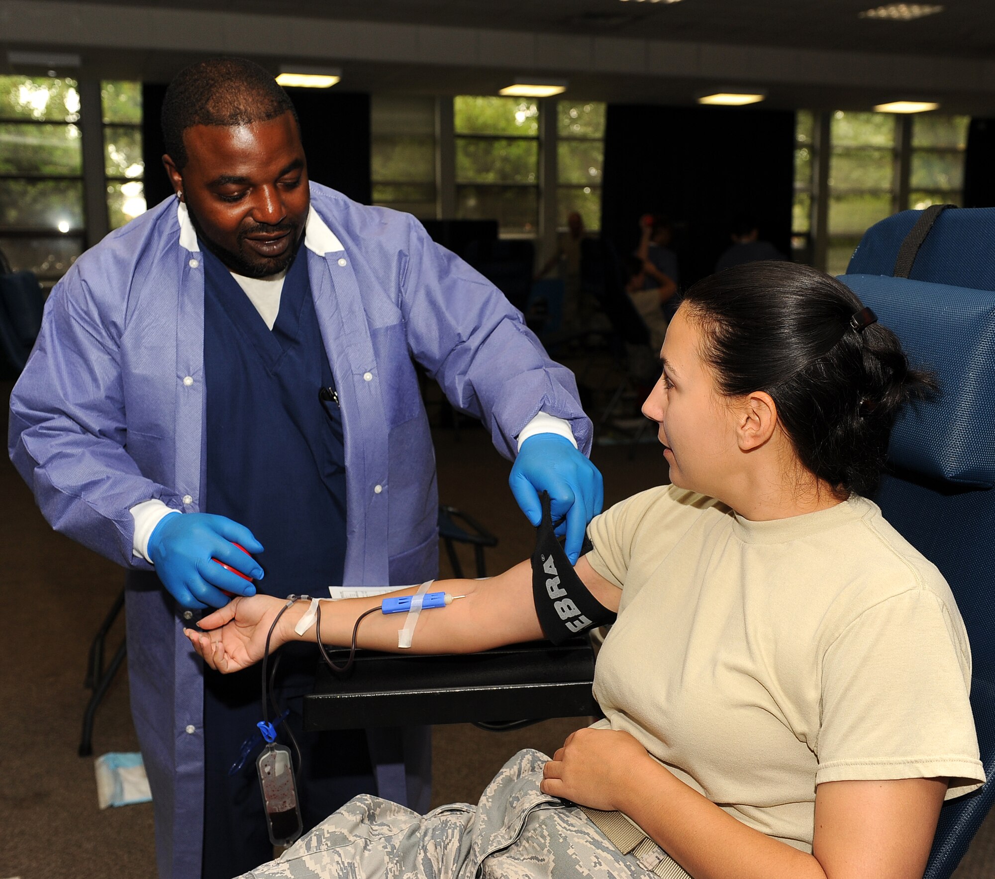 LANGLEY AIR FORCE BASE, Va. -- Daniel Belin, Naval Medical Center Portsmouth phlebotomist, loosens the tourniquet from Tech. Sgt. Cheri Morgan, Air Combat Command Surgeon General manager of medical manpower, during the Armed Services Blood Program blood drive at the Community Center Aug 4. The ASBP plays a key role in providing quality blood products for service members and their families in both peace and war. (U.S. Air Force photo/ Senior Airman Gul Crockett)