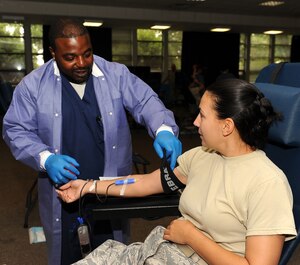 LANGLEY AIR FORCE BASE, Va. -- Daniel Belin, Naval Medical Center Portsmouth phlebotomist, loosens the tourniquet from Tech. Sgt. Cheri Morgan, Air Combat Command Surgeon General manager of medical manpower, during the Armed Services Blood Program blood drive at the Community Center Aug 4. The ASBP plays a key role in providing quality blood products for service members and their families in both peace and war. (U.S. Air Force photo/ Senior Airman Gul Crockett)
