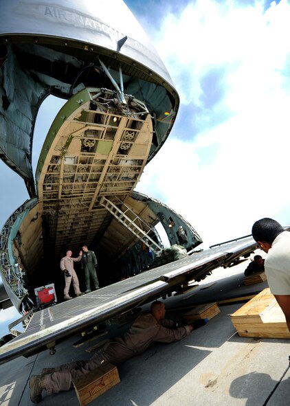 Airmen with the West Virginia Air National Guard and the 437th Aerial Port Squadron adjust the angle of the C-5 cargo ramp to accommodate oversized cargo July 30, 2010, on Joint Base Charleston, S.C. Hardwood blocks were positioned beneath the C-5 cargo ramp supports as shoring to allow the vehicle operator to drive a 35-foot water drilling truck into the C-5's cargo hold without scraping the aircraft cargo ramp or the pavement. (U.S. Air Force photo/Senior Airman Timothy Taylor)