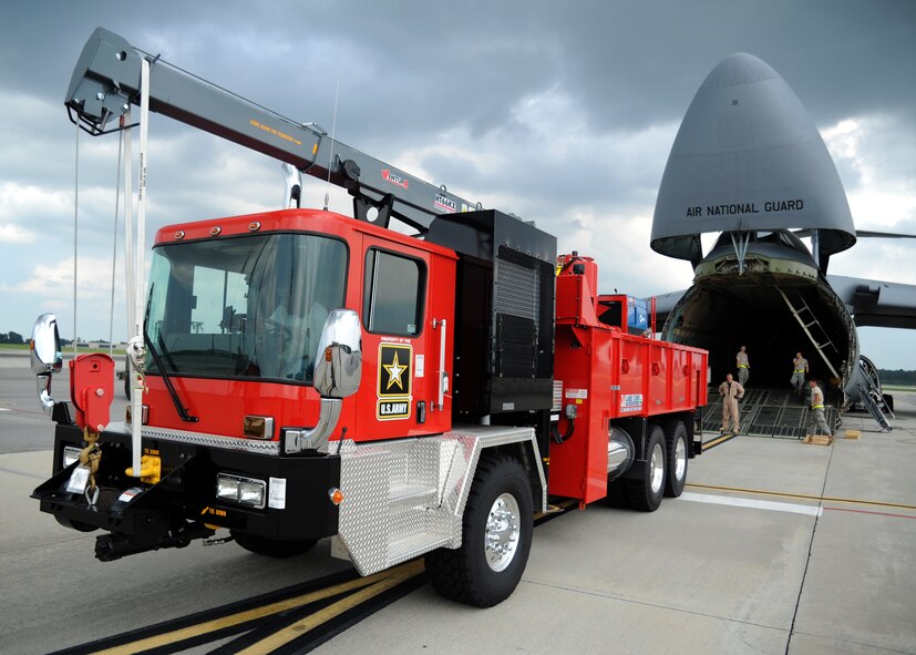 Airmen with the West Virginia Air National Guard and 437th Aerial Port Squadron stand ready to load a C-5 Galaxy as a vehicle operator starts up a V-2000NG well drilling truck July 30, 2010, on Joint Base Charleston, S.C. The V-2000NG is manufactured by Laibe Corp who was contracted by the Army. The water drilling system is designed to drill wells as deep as 5,000 feet and will provide U.S. forces clean water at the source rather than trucking water to the base of operations. By creating a local water source, the need for water transportation by convoy is reduced. (U.S. Air Force photo/Senior Airman Timothy Taylor)