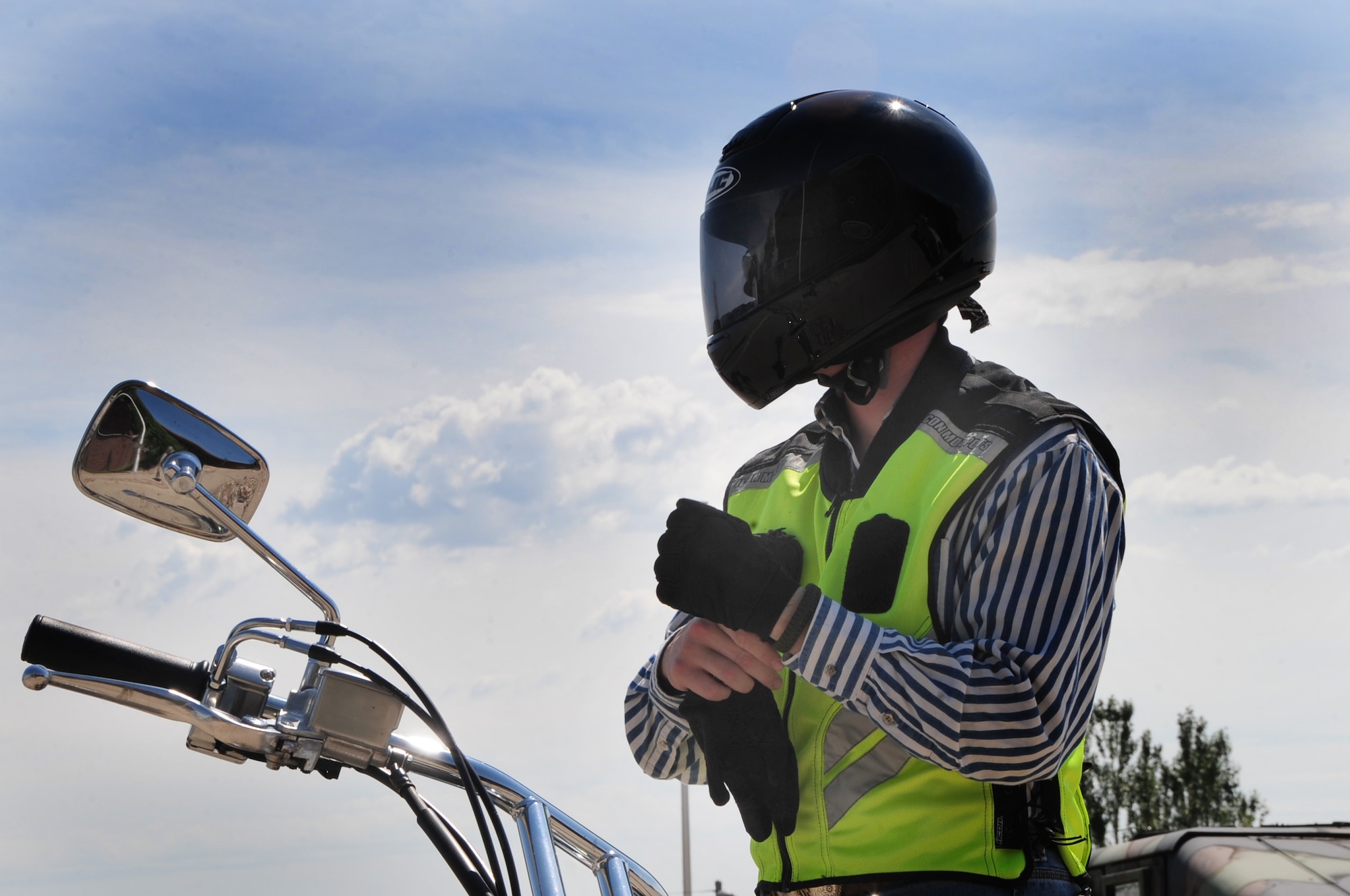 ELLSWORTH AIR FORCE BASE, S.D. -- Airman 1st Class James Mason, 28th Civil Engineer Squadron heating, ventilation and air-conditioning technician, puts on his full-finger gloves before going for a motorcycle ride, Aug. 3.  It is mandatory for Airmen to wear full fingered gloves for all military members, but it is also an effective protective measure to keep the rider’s hands safe in case of an accident. (U.S. Air Force photo/Airman 1st Class Anthony Sanchelli)