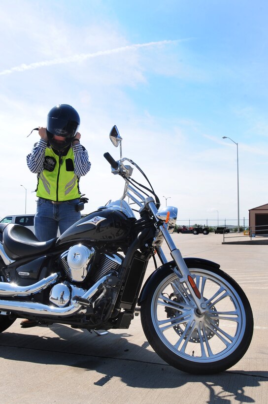 ELLSWORTH AIR FORCE BASE, S.D. -- Airman 1st Class James Mason, 28th Civil Engineer Squadron heating, ventilation and air-conditioning technician, puts on his helmet before going for a motorcycle ride, Aug. 3.  Wearing a helmet while riding is not only mandatory on base, but it can also save the rider’s life in the event of an accident. (U.S. Air Force photo/Airman 1st Class Anthony Sanchelli)