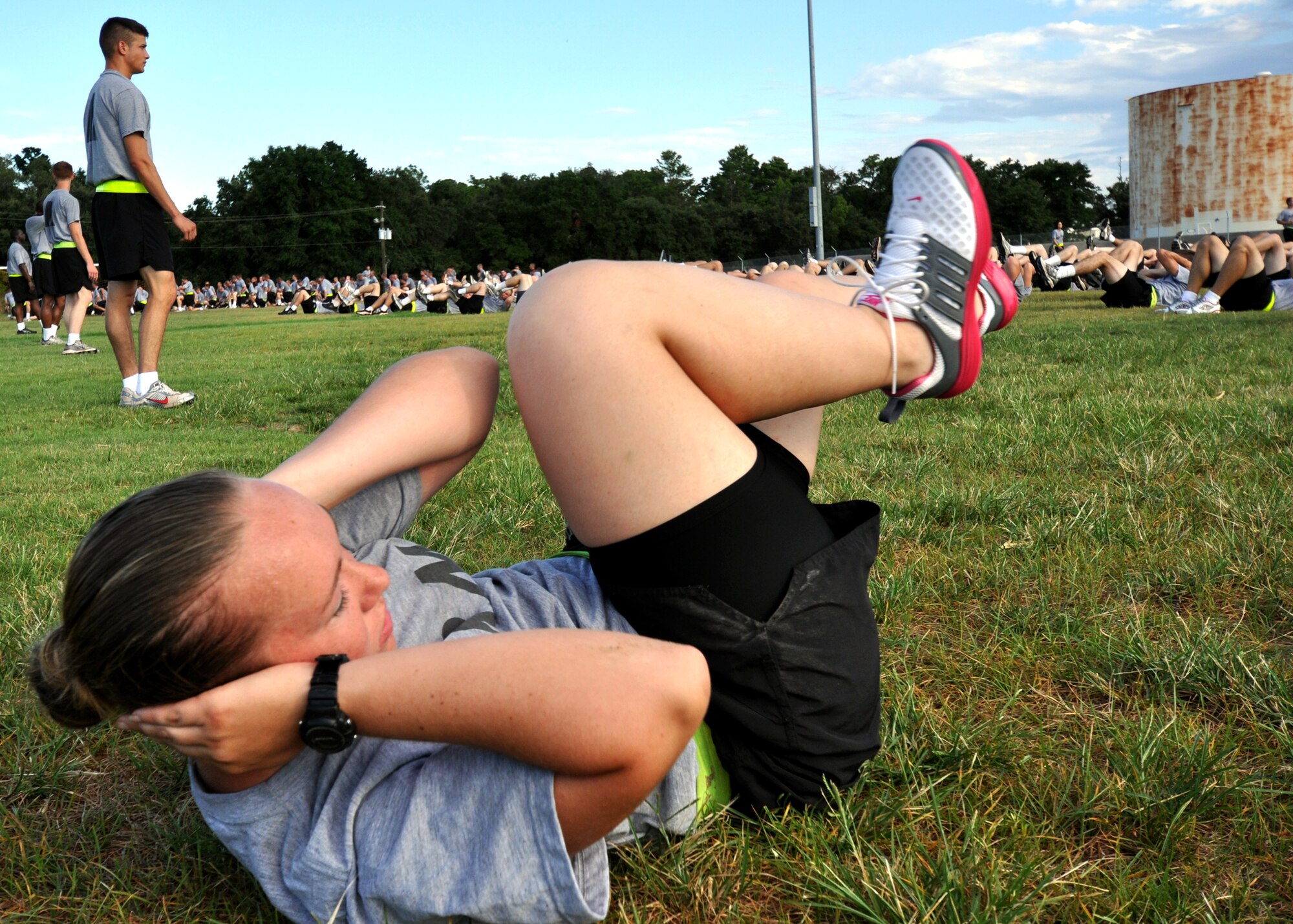 Pvt. Sara Barva leads the group in bicycle crunches during an afternoon physical training session at Eglin Air Force Base, Fla.  The 450 members of Bravo Company exercise four days a week after EOD classes end.  Combined with Alpha Company, there are approximately 750 Soldiers in stages of training at the 35-week Navy EOD course located at Eglin.  (U.S. Air Force photo/Tech Sgt. Cheryl Foster.) 