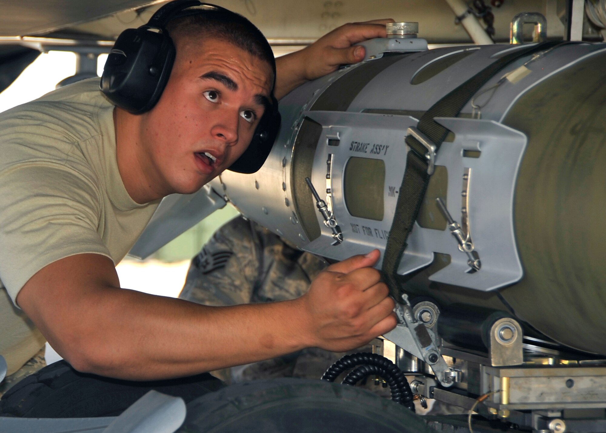 HOLLOMAN AIR FORCE BASE, N.M. -- Senior Airman Andrew Borger, 49th Aircraft Maintenance Squadron, removes the binding strap from a Guided Bomb Unit 32 Joint Direct Attack Munition prior to loading it on an F-22 Raptor during the Weapons Load Crew Competition July 30, 2010. This friendly competition, held every quarter, requires crew members to load F-22 Raptors and MQ-9 Reapers with munitions within 30 minutes. Winners from each crew get plaques as well as a traveling trophy. (U.S. Air Force photo by Senior Airman Veronica Stamps/ Released)