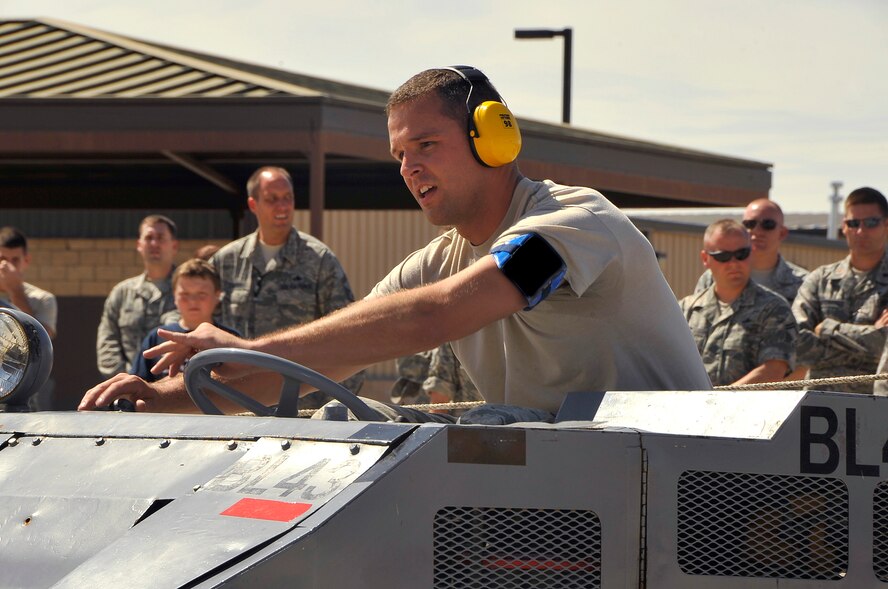 HOLLOMAN AIR FORCE BASE, N.M. -- Airman 1st Class Albert Lucas, 49th Aircraft Maintenance Squadron, watches his load crew chief for instructions on where to maneuver the MJ-1 Bomb lift Truck during the Weapons Load Crew Competition July 30, 2010. This friendly competition, held every quarter, requires crew members to load F-22 Raptors and MQ-9 Reapers with munitions within 30 minutes. Winners from each crew get plaques as well as a traveling trophy. (U.S. Air Force photo by Senior Airman Veronica Stamps/ Released)
