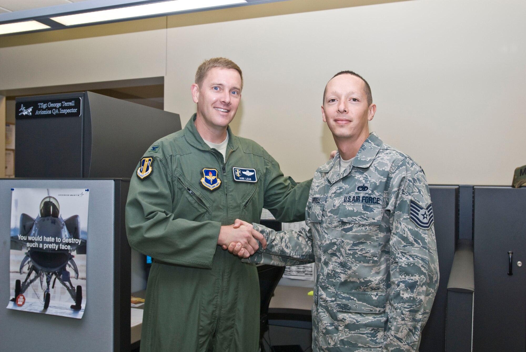 Col. Kirk Lear, 314th Airlift Wing vice commander, presents a coin Aug. 4 to Tech. Sgt. George Terrell, 314th Maintenance Operations Squadron instrument and flight control systems quality assurance inspector, for his selection as the Combat Airlifter of the Week. Sergeant Terrell authored the C-130J aircraft systems capabilities presentation for the recent Indian air force visit. (U.S. Air Force photo by Staff Sgt. Nestor Cruz)