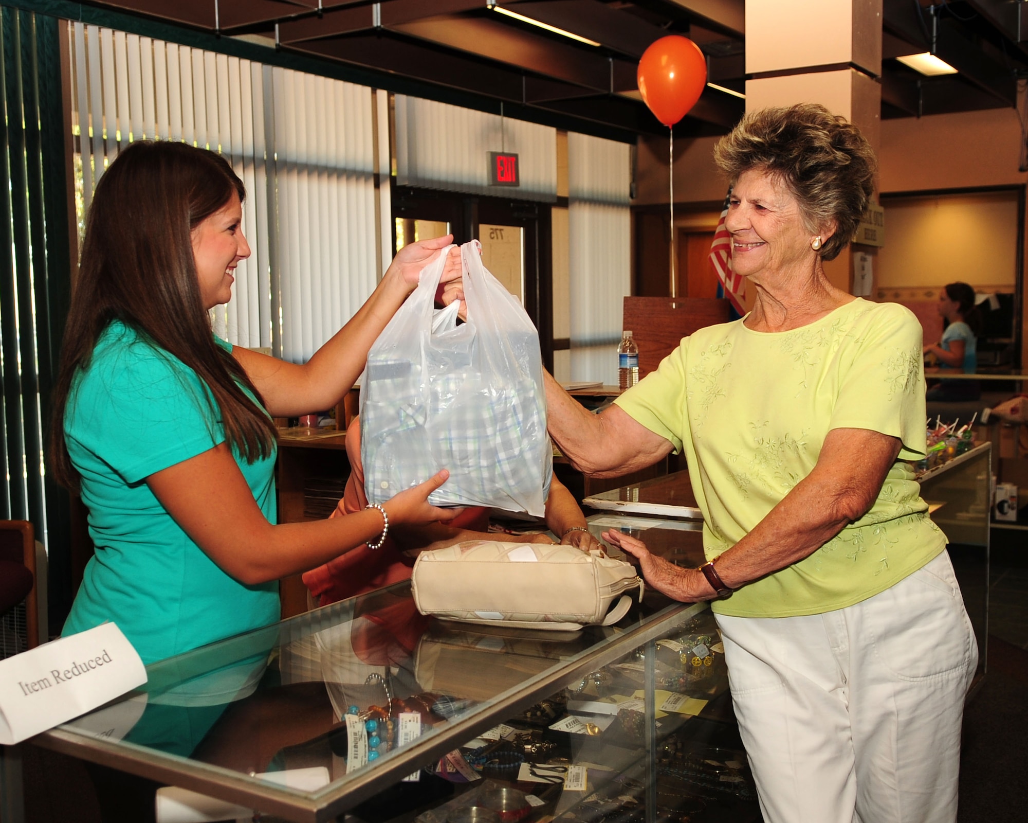 Ashley Catlin (left), a volunteer at the Davis-Monthan Thrift Shop, hands
Gudrun Patrick her purchased goods during the store's grand reopening event
here Aug. 3, 2010. Located in Bldg. 4201, the D-M Thrift Shop offers a wide
variety of goods for sale, including household furniture, clothes, books and
collectibles from all over the world. (U.S. Air Force photo/Airman 1st Class
Jerilyn Quintanilla)

