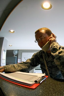 WHITEMAN AIR FORCE BASE, Mo. - Airman 1st Class Brandon Mills, 509th Operations Support Squadron airfield management, conducts the daily secondary crash phone test Aug. 4, ensuring all required agencies are able to respond during an in-flight or ground emergency. Airfield management has coordinated emergency response for more than 30 in-flight and ground emergencies since January. (U.S. Air Force photo/Senior Airman Jason Barebo)