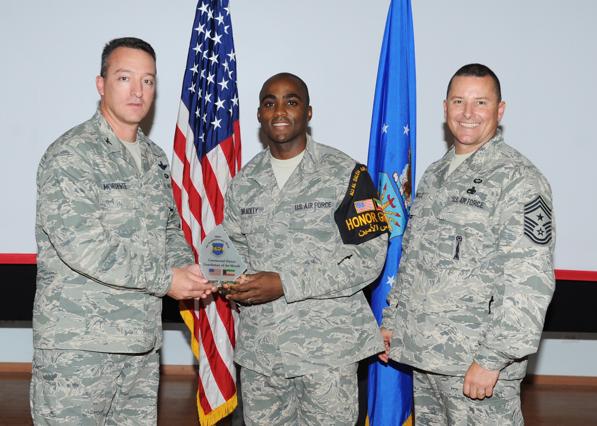Staff Sgt. Quintin Bradley, currently deployed from the 48th Force Support Squadron, is recognized by 386th Air Expeditionary Wing Commander Col. Patrick Mordente and Command Chief Master Sgt. Richard Turcotte Jr. in Southwest Asia August 2. Sergeant Bradley was named both NCO and Honor Guardsman of the Month. (U.S. Air Force photo/Senior Airman Laura Turner)