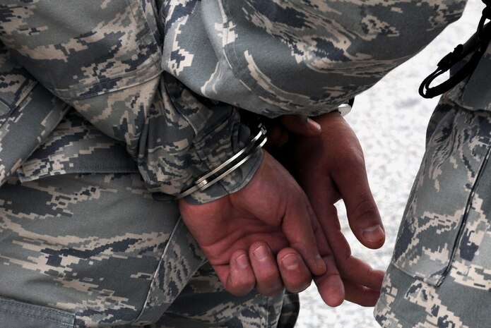 Senior Airman Nathaniel Williams handcuffs  Master Sgt. Sloan Kalina during a quality control exercise on Joint Base Charleston, S.C., July 28, 2010. The scenario consisted of a gate runner with a concealed weapon. The exercise was conducted to test the skills of security forces Airmen tasked with apprehending the suspect. Airman Williams and Sergeant Kalina are both with the 628th Security Forces Squadron. (U.S. Air Force Photo/Airman 1st Class Lauren Main)