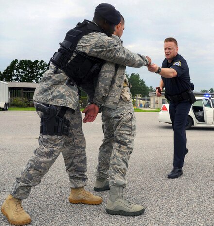 Senior Airman Nathaniel Williams searches Master Sgt. Sloan Kalina and passes an item of suspicion to Officer William Broach during a quality control exercise on Joint Base Charleston, S.C., July 28, 2010. The quality control check is comprised of numerous aspects which include a written test, a verbal exam, subject matter test, weapons training and a scenario for security forces Airmen to respond to. Sergeant Kalina, Airman Williams and Officer Broach are assigned to the 628th Security Forces Squadron. (U.S. Air Force Photo/Airman 1st Class Lauren Main)