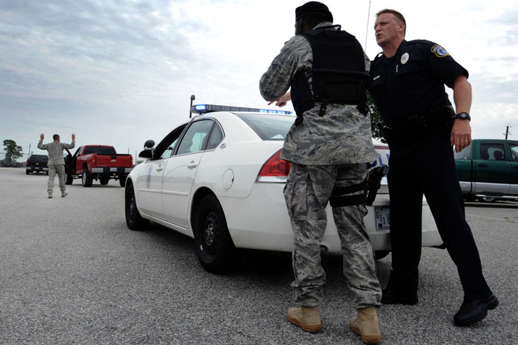 Senior Airman Nathaniel Williams, joined by Officer William Broach, right, shouts for Master Sgt. Sloan Kalina to back up to the sound of his voice during a quality control exercise on Joint Base Charleston, S.C., July 28, 2010. The role play scenario was used to qualify security forces Airmen for patrol. Sergeant Kalina, Airman Williams and Officer Broach are assigned to the 628th Security Forces Squadron. (U.S. Air Force Photo/Airman 1st Class Lauren Main)