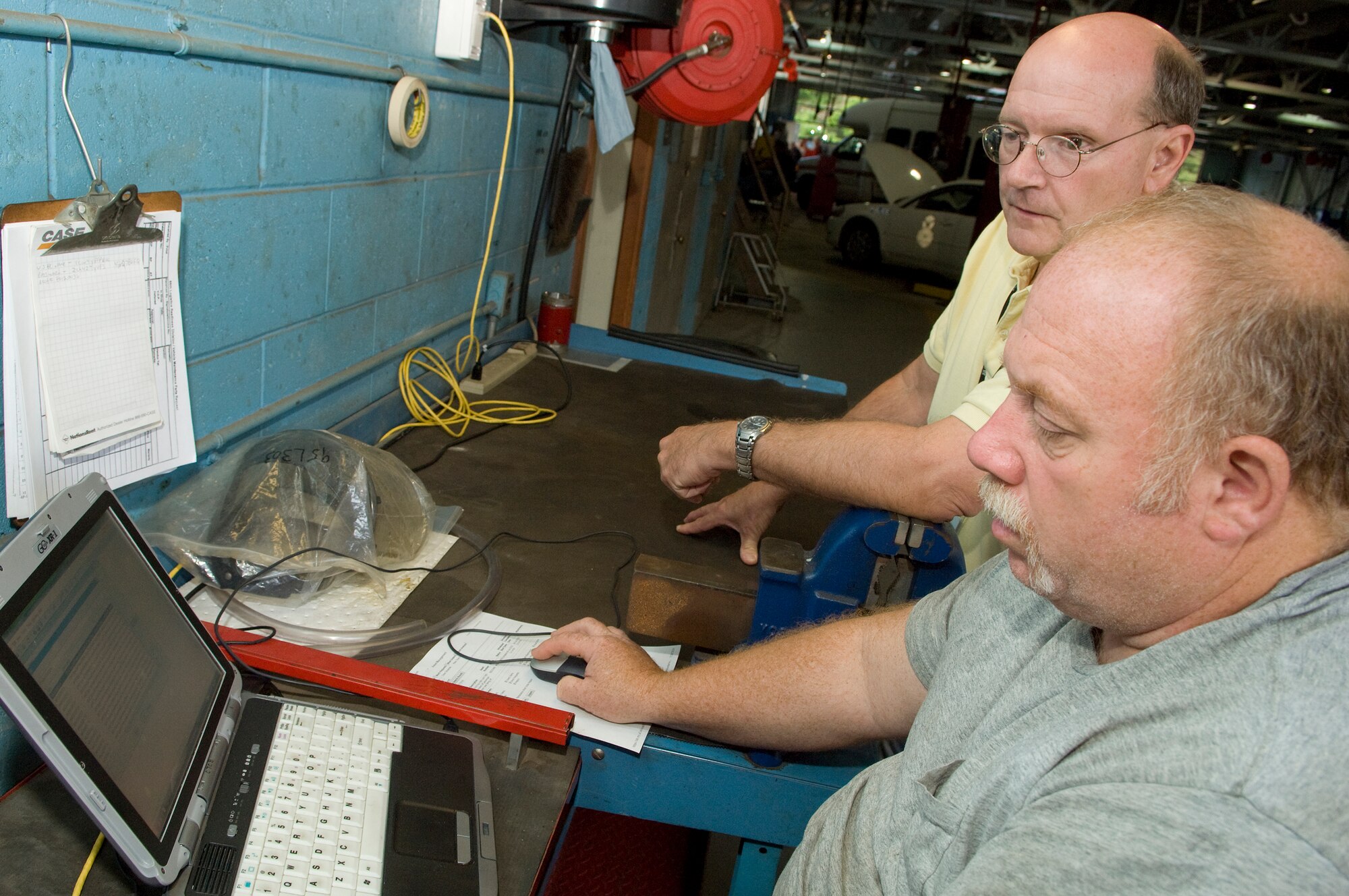 Rick Lord, a fire apparatus maintainer in the 66th Logistics Squadron, opens the first work order using the Expeditionary Combat Support System at Hanscom Aug. 2, as Fritz Cooper of CSC looks on.  Hanscom is the pilot base for implementing ECSS, which will ultimately be used by over 40,000 people at approximately 180 installations. (U.S. Air Force photo by Mark Wyatt)