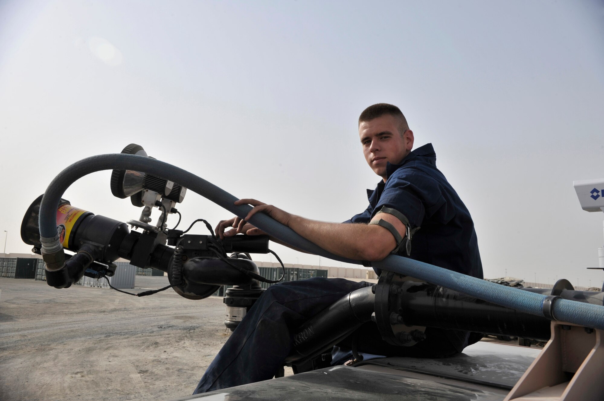 Senior Airman Jared Hopper, 380th Expeditionary Logistics Readiness Squadron fire truck mechanic, poses for a photo with the roof turret he repaired at an undisclosed location in Southwest Asia Aug. 3. Airman Hopper installed a $13,000 camera, rebuilt the turret motor and prepared the new 2010 Striker fire truck with a limited technical inspection with the help of Staff Sgt. Brian Roub a 380th ELRS vehicle mechanic. (U.S. Air Force photo/ Tech Sgt. April Wickes)