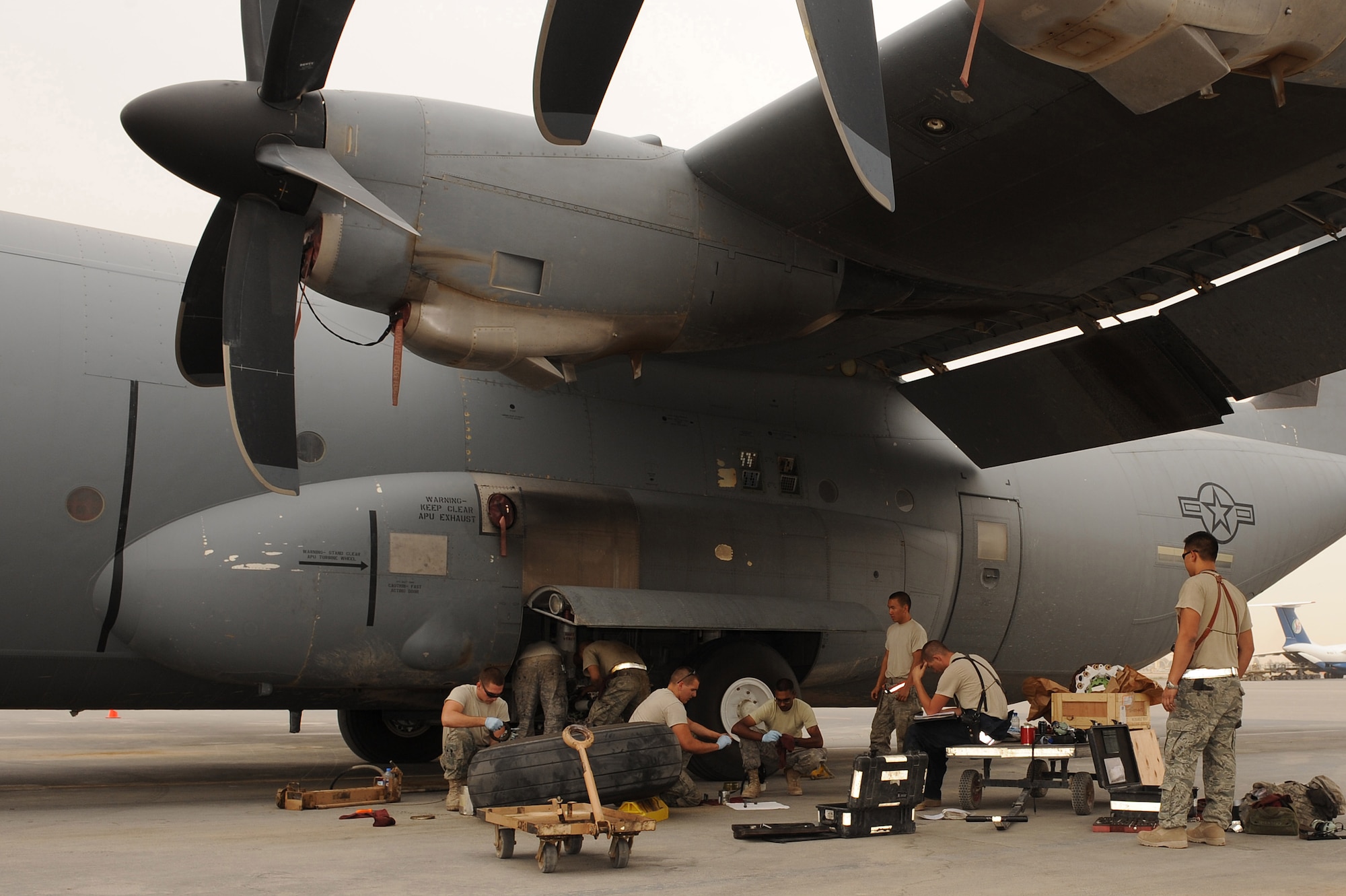 Airmen, of the 451st Expeditionary Aircraft Maintenance Squadron, Kandahar Airfield, Afghanistan, work together to change a brake assembly on a C-130J Hercules Aug. 2, 2010.  The Airmen are currently deployed from Little Rock Air Force Base, Ark.  (U.S. Air Force photo by Tech. Sgt. Chad Chisholm/Released)