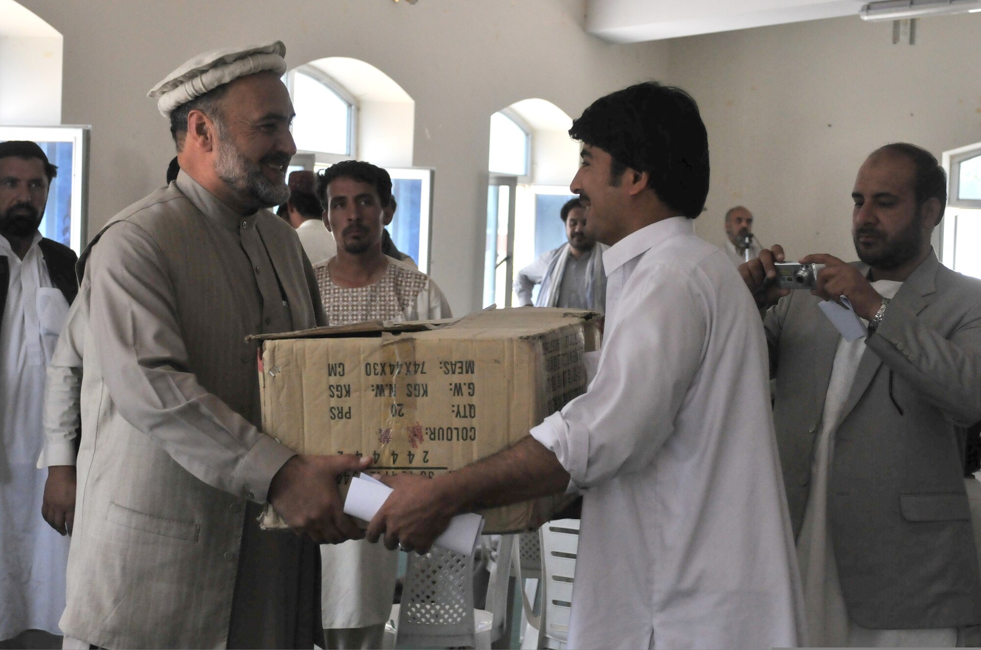 QALAT CITY, Afghanistan -- Zabul Provincial Governor Ashraf Naseri hands volleyball equipment to a local volleyball coach in Qalat City, Zabul Province, Aug. 1, 2010. The equipment was donated by the Zabul Provincial Governor and Provincial Reconstruction Team Zabul. The volleyball coaches received new volleyballs, shoes, uniforms and nets for the upcoming season. (U.S. Air Force photo/Senior Airman Nathanael Callon)
