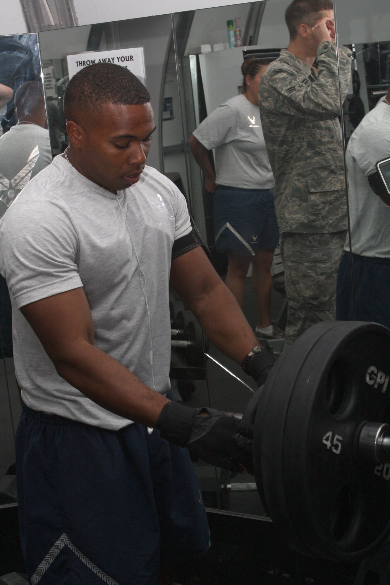Staff Sgt. Marcus Goodloe, Expeditionary Civil Engineer Squadron, adds weight to a bar bell during a bench press competition July 31 at an undisclosed location in Southwest Asia. Nine Airmen competed in the competition, Airman 1st Class Joshua Carabajal, 380th Expeditionary Security Forces Squadron, won first place and Senior Master Sgt. Samuel Freeman, 380th Logistics Readiness Squadron took second place. (U.S. Air Force Photo/Staff Sgt. del Castillo) 
