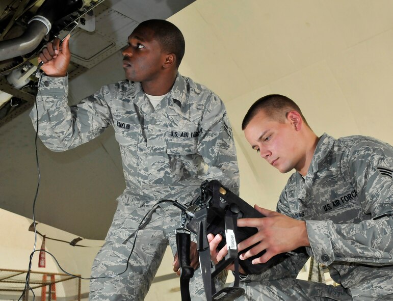 Airman 1st Class Courtney Finklin and Senior Airman Jon Pacunas, 332nd Expeditionary Maintenance Squadron Non-Destructive Inspection Lab technicians, use an eddy current detector to check for surface cracks around a nut plate July 28, 2010, Joint Base Balad, Iraq.  The term eddy current comes from similar currents seen in water. Airman Finklin is a native of Fort Lauderdale, Fla., and Airman Pacunas is a native of Davenport, Iowa, both are deployed form Shaw Air Force Base, S.C. (U.S. Air Force photo/Staff Sgt. Phillip Butterfield)