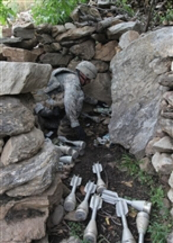A U.S. Army soldier from 1st Battalion, 327th Infantry Regiment, 101st Airborne Division finds a cache of mortar rounds outside the town of Barge Matal as part of Operation Azmaray Fury in Kunar province, Afghanistan, on July 28, 2010.  