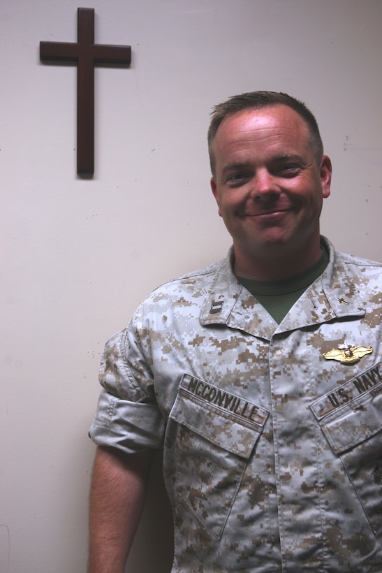 Navy Lt. Mike McConville, battalion chaplain for the Marine Combat Training Battalion, School of Infantry - East, stands next to a wooden cross in his office aboard Camp Geiger, Aug. 5. McConville, a former Marine, uses his prior enlistment as a tool for helping Marines who come to him in need of help.