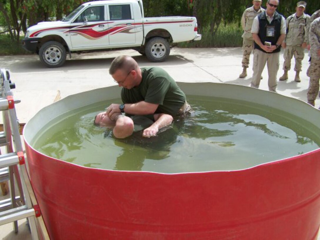 Navy Lt. Mike McConville (right), current battalion chaplain for the Marine Combat Training Battalion, School of Infantry - East, baptizes a Marine with 2nd Battalion, 10th Marine Regiment, 2nd Marine Division, during a deployment to Fallujah, Iraq, in 2007. McConville, a former Marine infantryman, decided to become a Navy chaplain because he wanted to serve both God and the Corps.