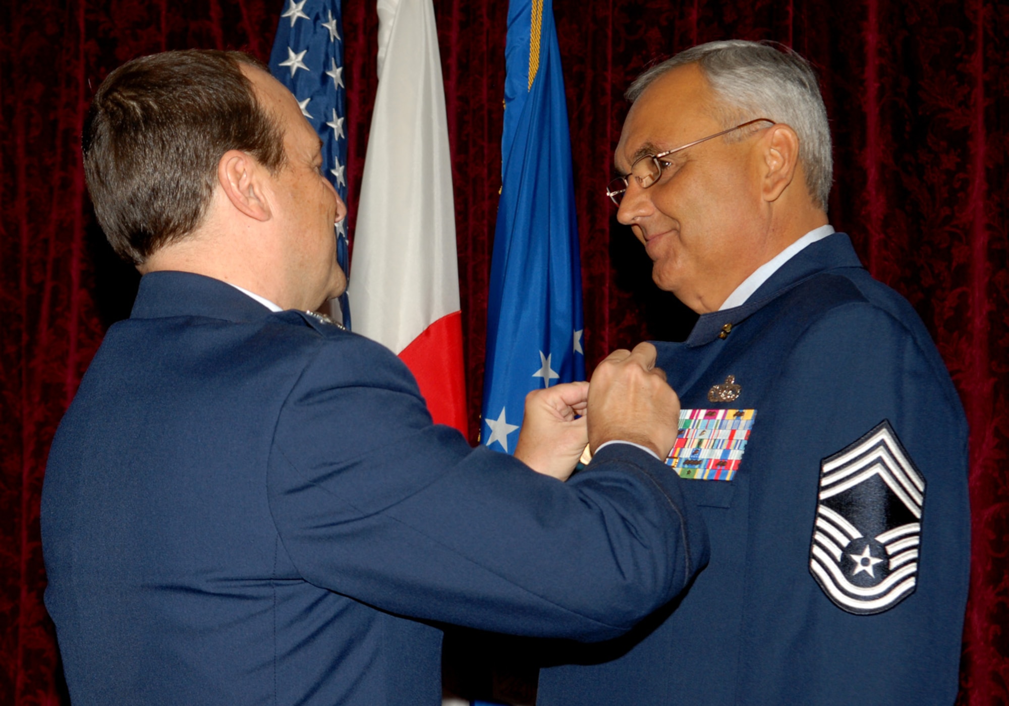 Col. Kelly Fletcher, former 18th Mission Support Group Commander, pins the Meritorious Service medal on Chief Master Sgt. Michael P. Donoven at his retirement ceremony June 9, 2010 at Kadena Air Base, Japan. Chief Donoven, the former 18th Mission Support Group Superintendent, passed away Aug. 4 in Arkansas. The Chief retired after 25 years of service to the United States Air Force (U.S. Air Force photo/Junko Kinjo)