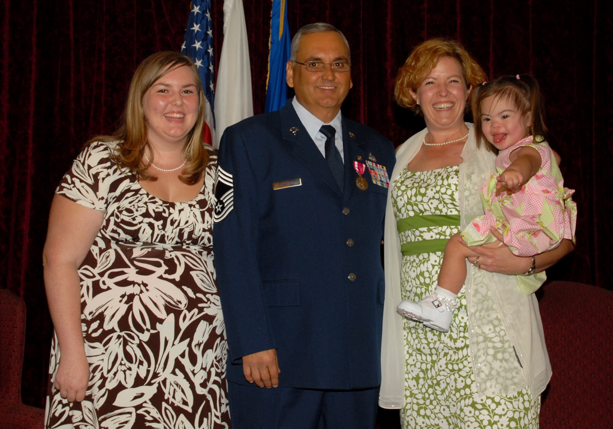 Chief Master Sgt. Michael P. Donoven stands with his family at his retirement ceremony June 9, 2010 at Kadena Air Base, Japan. Chief Donoven, the former 18th Mission Support Group Superintendent, passed away Aug. 4 in Arkansas. Pictured here from left to right are his daughter Amanda, Chief Donoven, his wife Kattie and his daughter Amanda. (U.S. Air Force photo/Junko Kinjo)