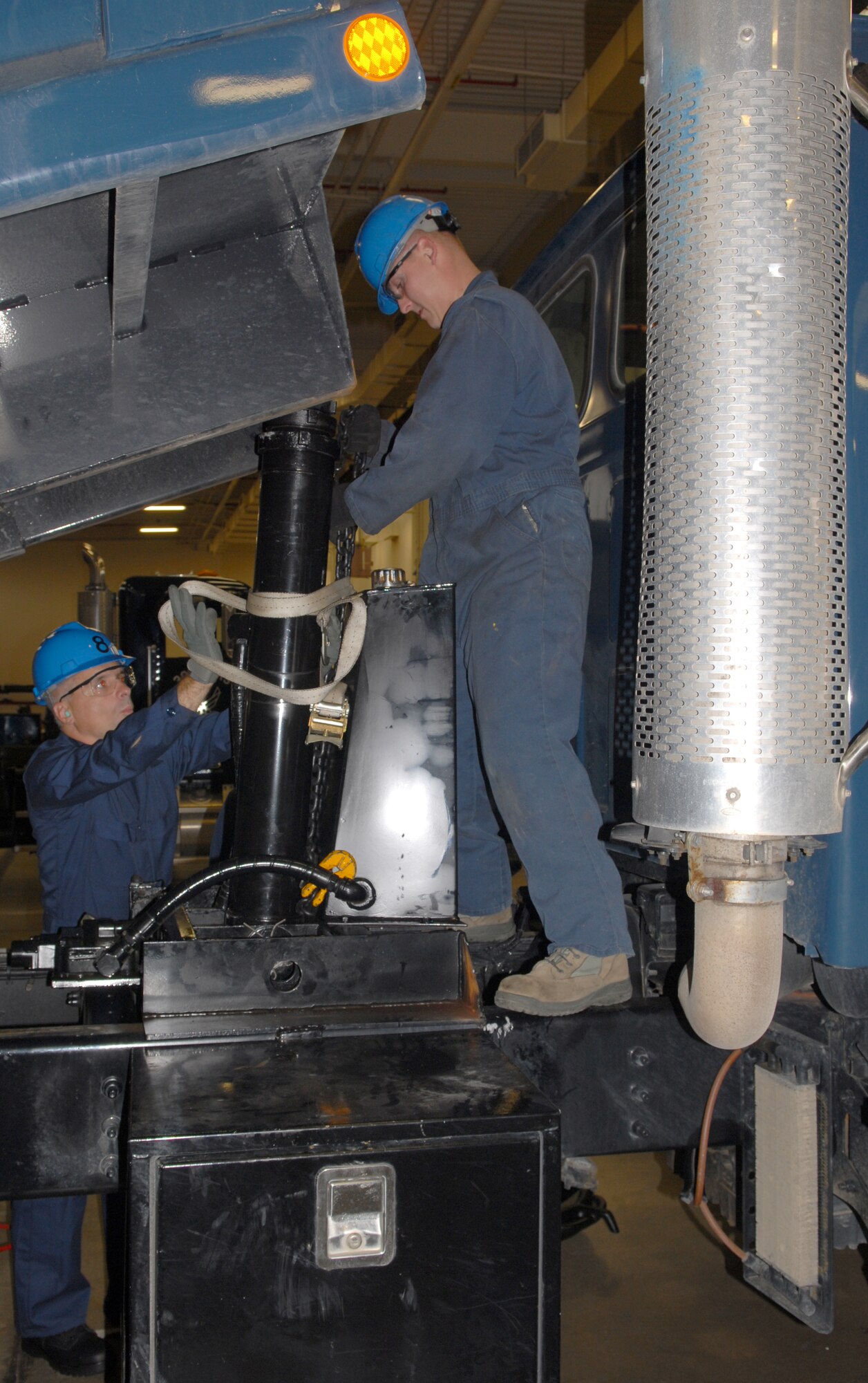 VANDENBERG AIR FORCE BASE, Calif.-- Col. Richard Boltz, the 30th Space Wing commander, and Staff Sgt. Brian Flynn, a 30th Logistic Readiness Squadron vehicle and equipment technician, properly insert the hydraulic cylinder into the Sterling dump truck here Thursday Aug. 5, 2010. Colonel  Boltz and Chief Master Sgt. Angelica Johnson, the 30th Space Wing command chief, will be partaking monthly in activities within Team V's work centers. (U.S. Air Force photo/Senior Airman Antoinette Gibson)