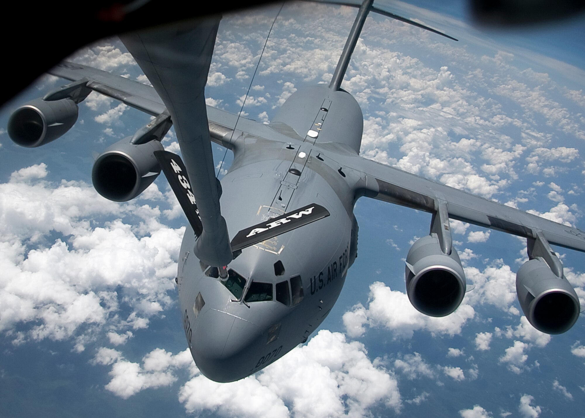 GRISSOM AIR RESERVE BASE, Ind. -- A C-17 Globemaster III from the 437th Airlift Wing flies behind a KC-135R Stratotanker from the 434th Air Refueling Wing during an aerial refueling mission Aug. 4. The 437th AW is based out of Joint Base Charleston, S.C. The C-17 Globemaster III is the newest, most flexible cargo aircraft to enter the airlift force. The KC-135 Stratotanker provides the core aerial refueling capability for the United States Air Force and has excelled in this role for more than 50 years. The C-17 is capable of rapid strategic delivery of troops and all types of cargo to main operating bases or directly to forward bases in the deployment area. (U.S. Air Force photo/Tech. Sgt. Mark R. W. Orders-Woempner) 