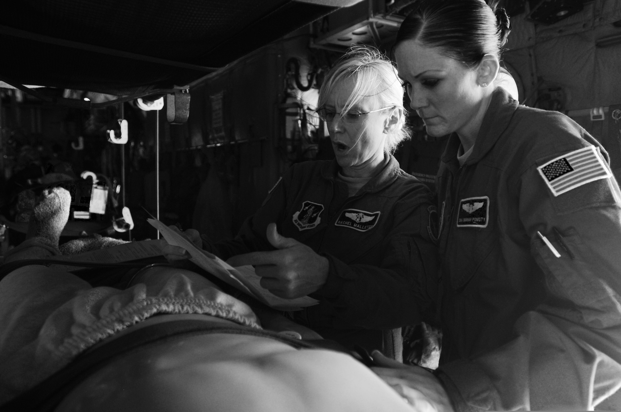 U.S. Air Force Maj. Rachel Mallette, left, reviews a medical chart with Senior Airman Mariah Pomotty while flying in a C-130 Hercules aircraft over North Carolina during an aeromedical readiness training mission July 29, 2010. Both Airmen are assigned to the 156th Aeromedical Evacuation Squadron, North Carolina Air National Guard. (DoD photo by Tech. Sgt. Brian E. Christiansen, U.S. Air Force/Released)