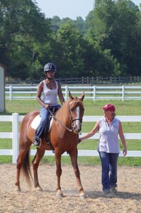 Spec. Emily Gordnier, a wounded warrior at the Fort Eustis Warrior in Transition Unit, rides Winston, a 14-year-old Tennessee Walking Horse as equine assisted therapy instructor Kim Wendell, walks alongside at the Dream Catchers at Cori Sikich Therapeutic Riding Center in Toano. Gordnier is taking part in an equine assisted therapy program partnered between the Eustis WTU and Dream Catchers.