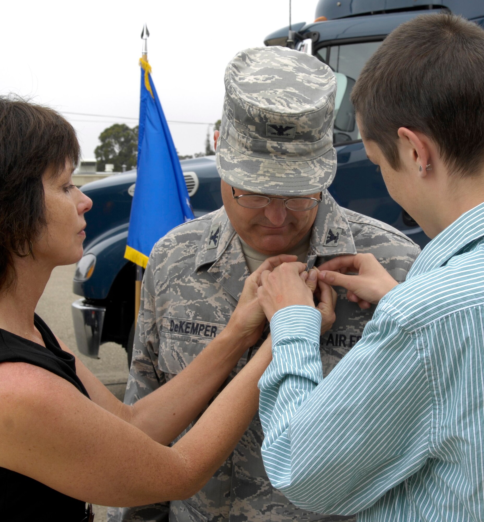 VANDENBERG AIR FORCE BASE, Calif. - The wife and son of Col. Carl DeKemper, the former 576th Flight Test Squadron commander, place a pin on Colonel DeKemper’s uniform during his retirement ceremony here Tuesday, Aug. 3, 2010. The pin is worn symbolically by retired servicemembers.  (U.S. Air Force photo/Airman 1st Class Lael Huss)