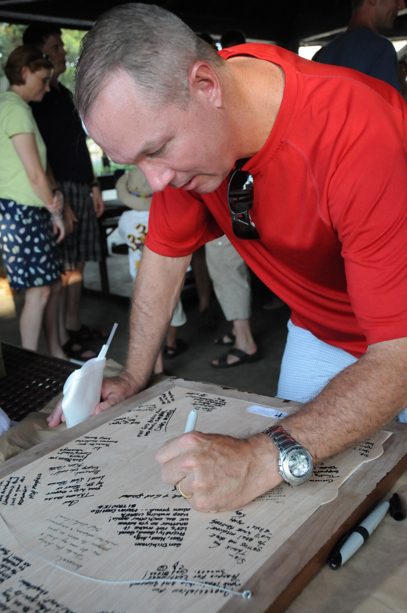 Lt. Col. Scott Solomon, 81st Training Group deputy commander, signs a farewell print for the Dickinsons.  (U.S. Air Force photo by Kemberly Groue)