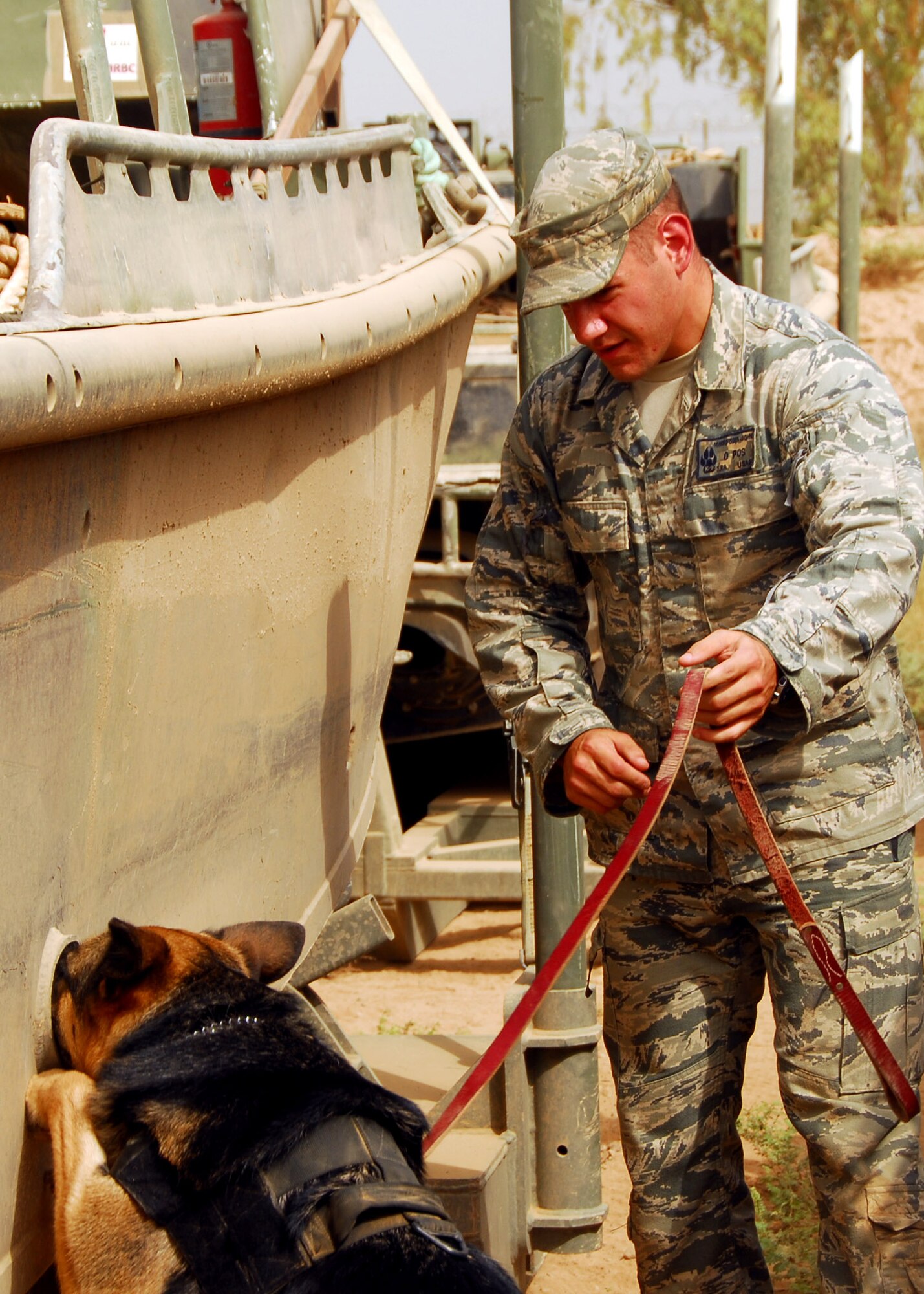 Bertha, a 332nd Expeditionary Security Forces Group military working dog, and her handler Senior Airman John Makripodis, search for explosives July 31, 2010, Joint Base Balad, Iraq. MWDs are trained to detect explosives and drugs.  Airman Makripodis is a native of Pittsburg, Penn., the dog team is deployed from Seymour Johnson Air Force Base, N.C. (U.S. Air Force photo/Senior Airman Marianne E. Lane)