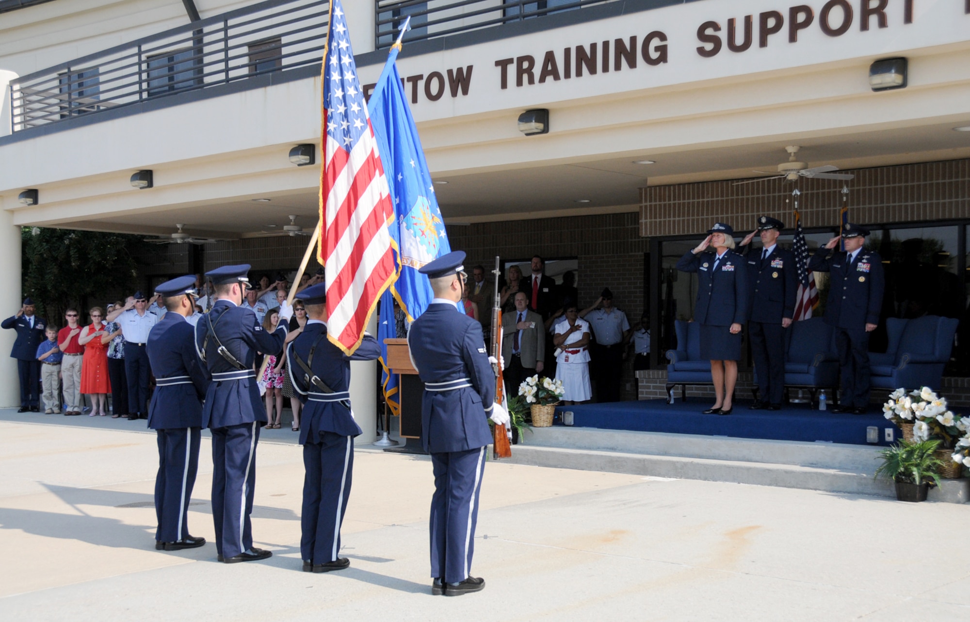 Military members salute and civilians place their right hand over their heart during Monday’s change of command ceremony as the National Anthem is sung.  (U.S. Air Force photo by Kemberly Groue)