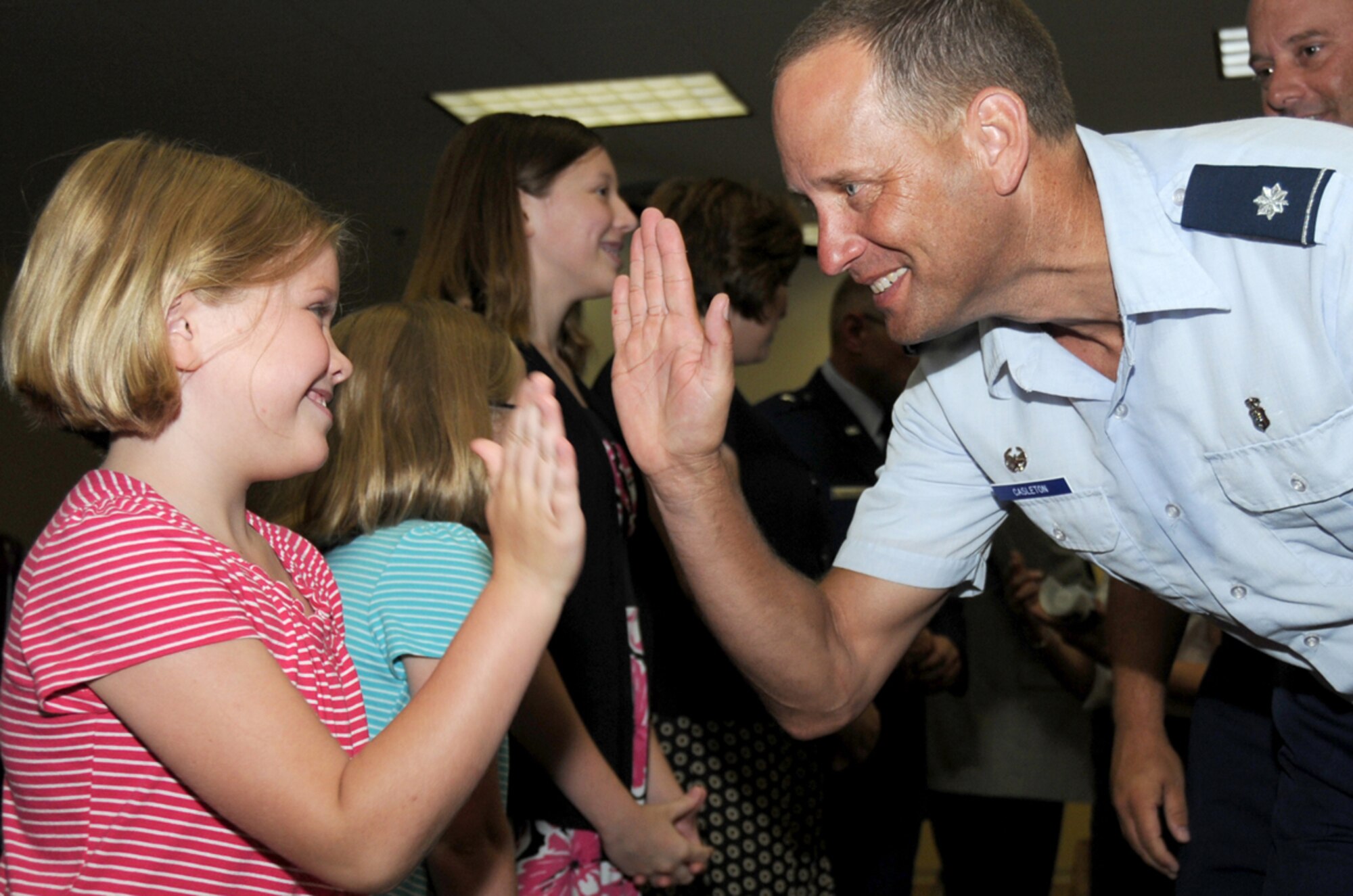 Sophie Mueller, 7, gets a “high five” from Lt. Col. Brian Casleton, 81st Aerospace Medicine Squadron commander, at a reception following the change of command ceremony.  Her sisters are Hailey, 10, and Maurie, 13.  (U.S. Air Force photo by Kemberly Groue)
