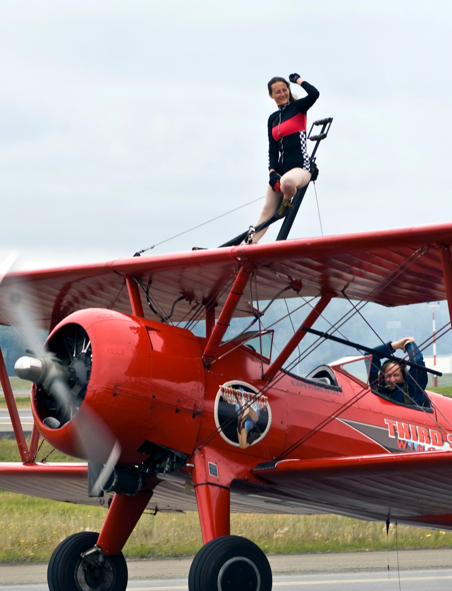JOINT BASE ELMENDORF-RICHARDSON, Alaska -- Carol Pilon, of Third Strike Wingwalking' demonstrated some wingwalking on a bi-plane as it flew through the skies during Joint Base Elmendorf-Richardson's Arctic Thunder Aug. 1. Arctic Thunder 2010, a two-day event, featured the U.S. Navy Blue Angels and the Canadian Forces Snowbirds Demonstration Team, along with many other aerial demonstrations and static displays. (Air Force photo by Airman 1st Class Christopher Gross) 
