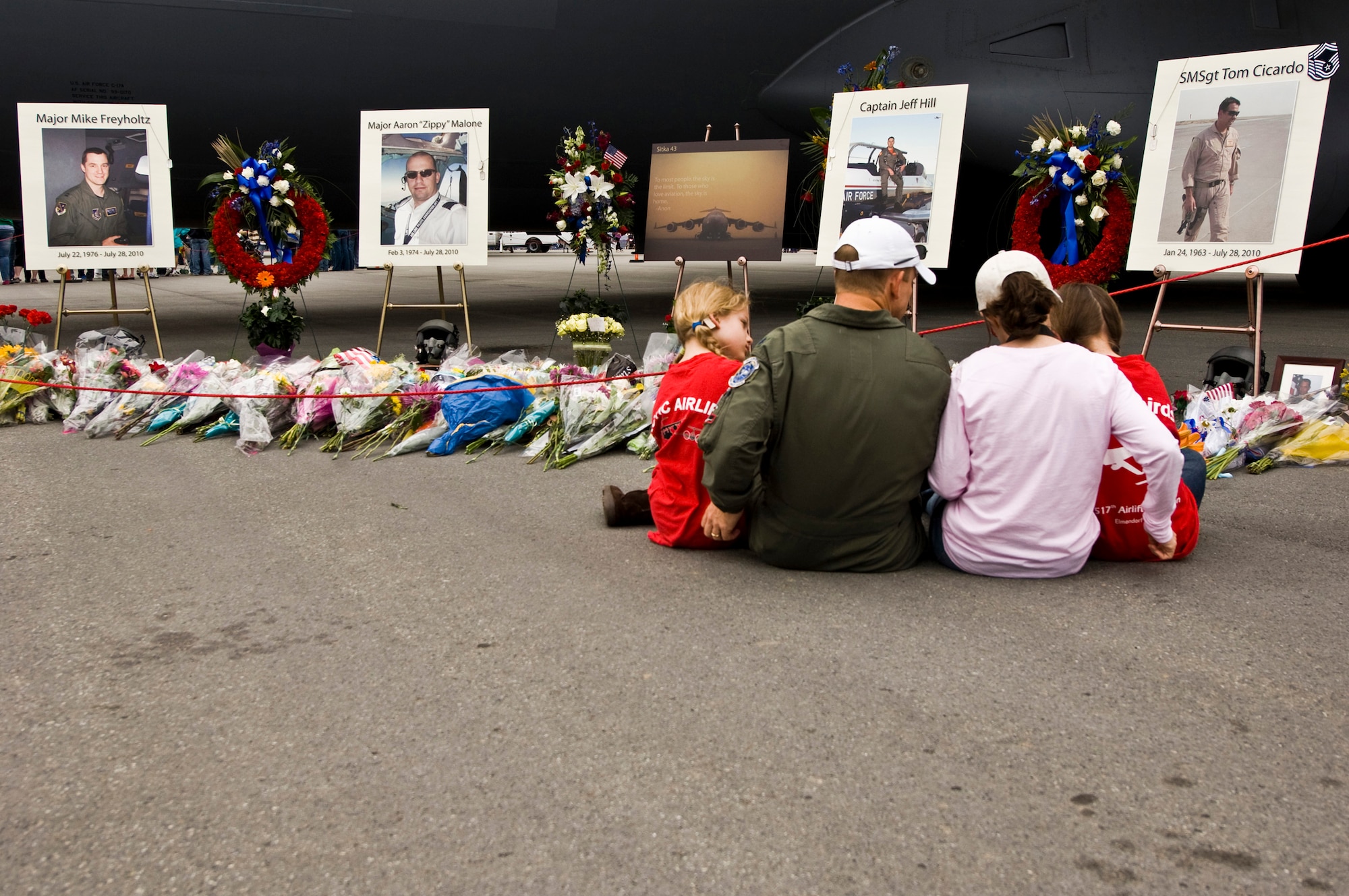 JOINT BASE ELMENDORF-RICHARDSON, Alaska -- A family sits and mourns the loss of the C-17 Globemaster III, Sitka 43, crew that lost their lives during a crash July 28.  A C-17 memorial was on display during Joint Base Elmendorf-Richardson's Arctic Thunder for those of who wanted to pay their respects. (Air Force photo by Airman 1st Class Christopher Gross) 
